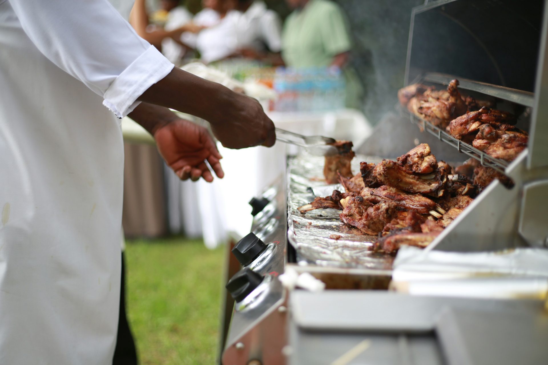 Persona cocinando en una parrilla exterior